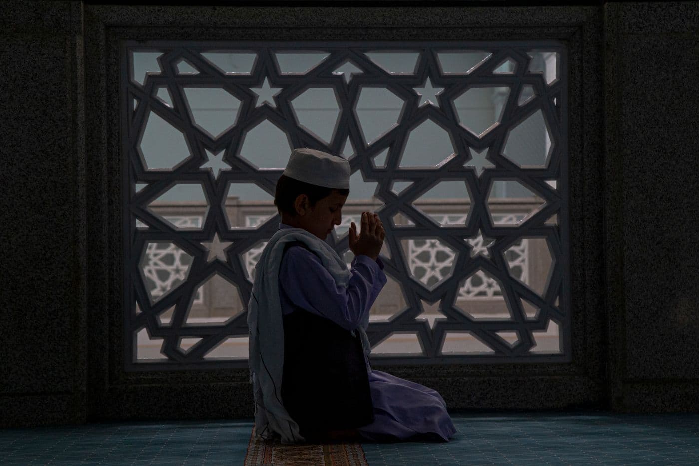 فتى يدعو في المسجد
